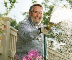 喷洒花园水管的男子